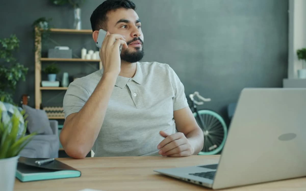 Business owner on the phone at a desk with a laptop open