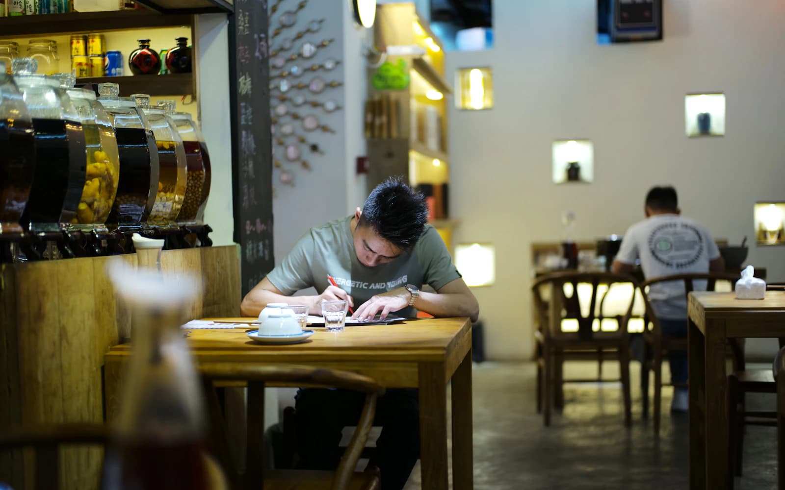 Restaurant owner reading and marking papers at a table in his dining room