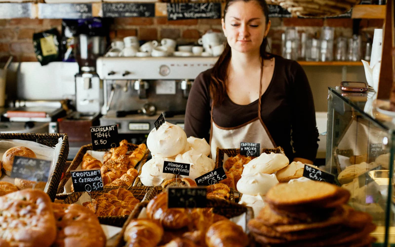Bakery owner behind her counter of fresh pastries