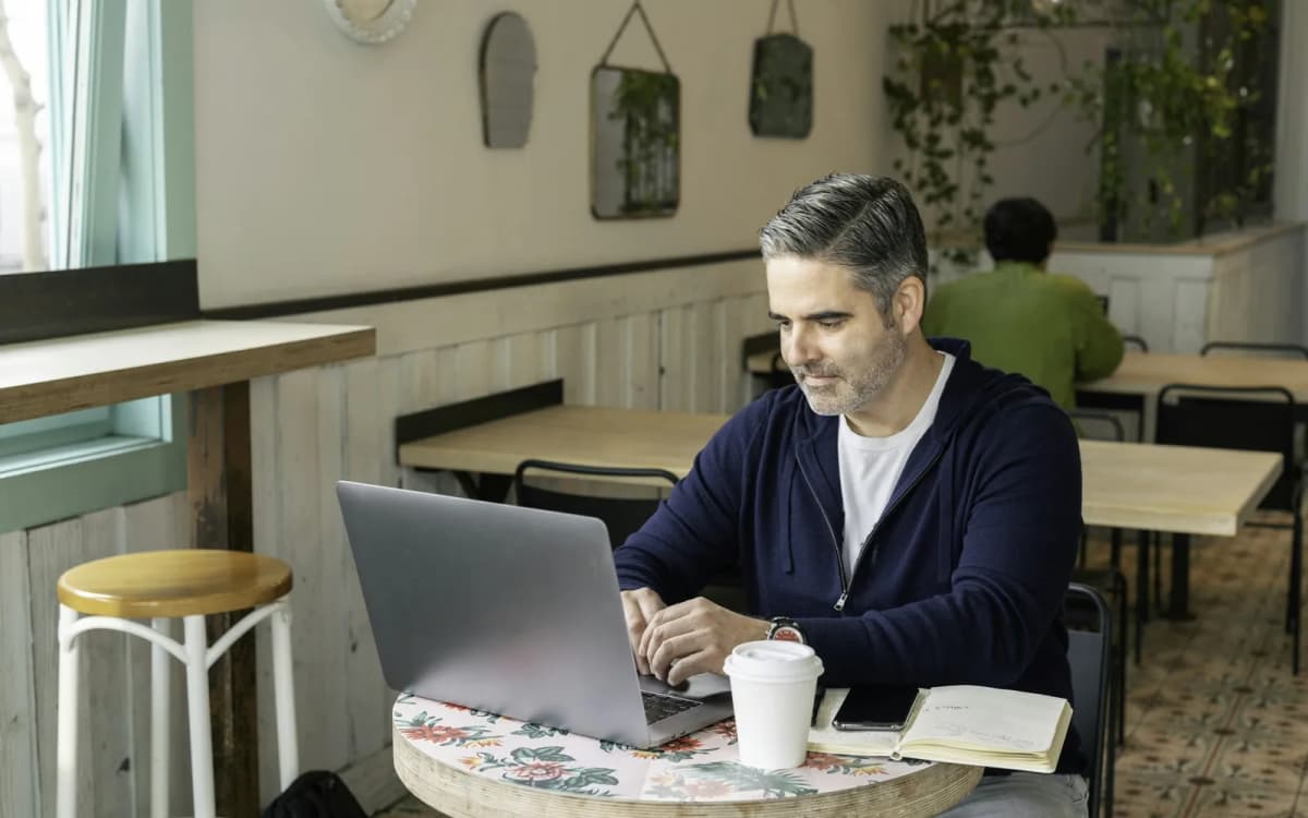 Restaurant owner reviewing the business account on a laptop at a table in the dining room