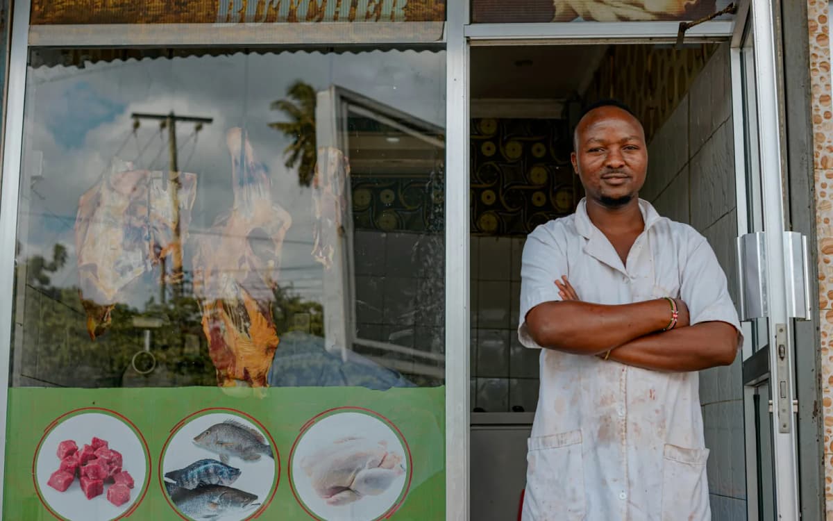 Small business owner standing with arms crossed in the doorway of the shop they occupy