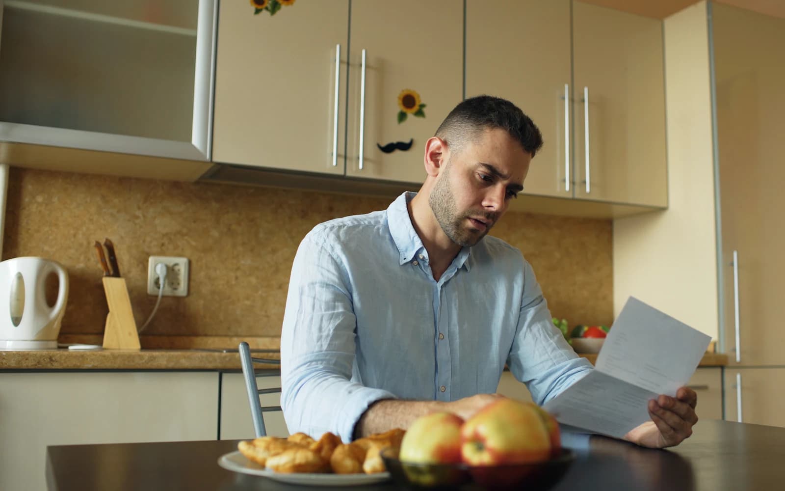 Business owner reading a printed document at his kitchen table