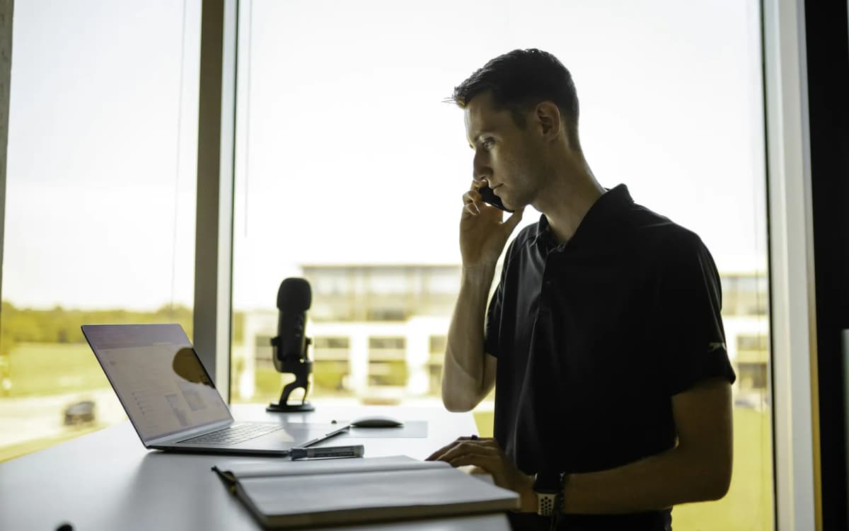 Business owner on a call with a funding advisor, laptop and notes open on the desk