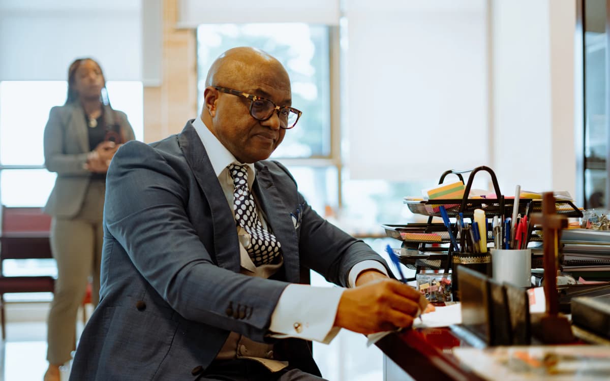 Business owner in a suit reading and marking a document at his desk