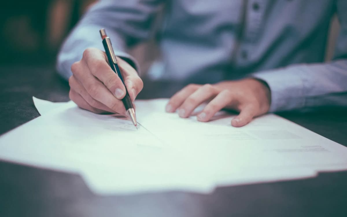 Business owner reading through a printed agreement with a pen in hand