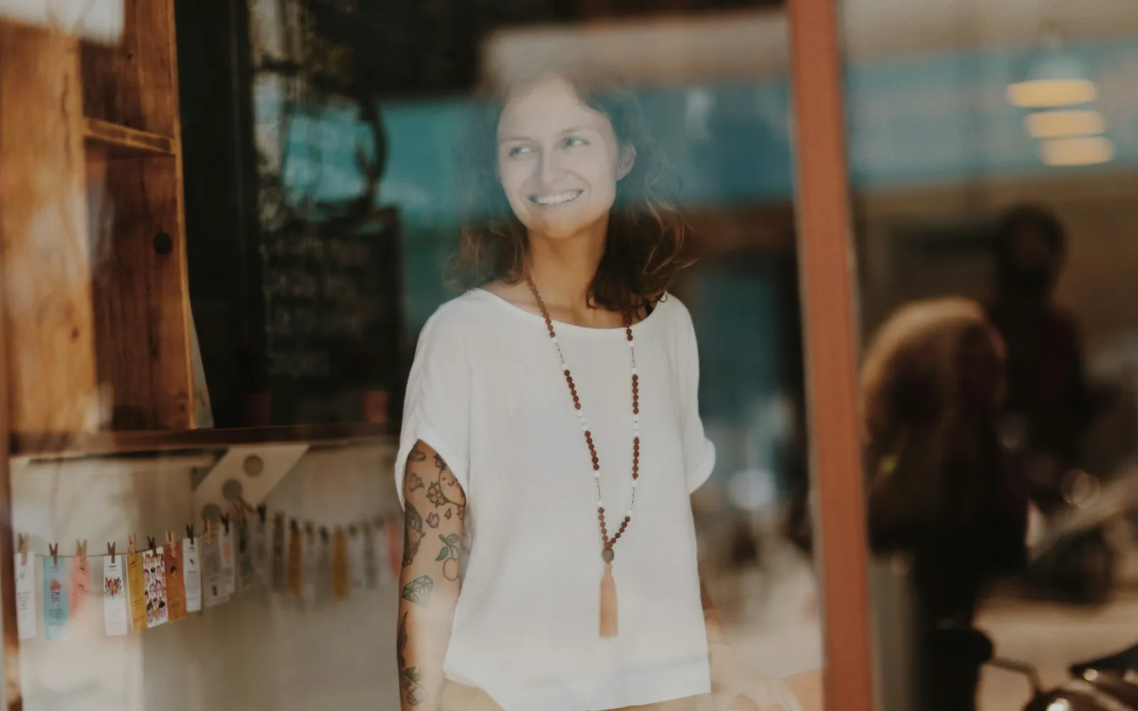 Smiling new shop owner seen through the front window of the shop